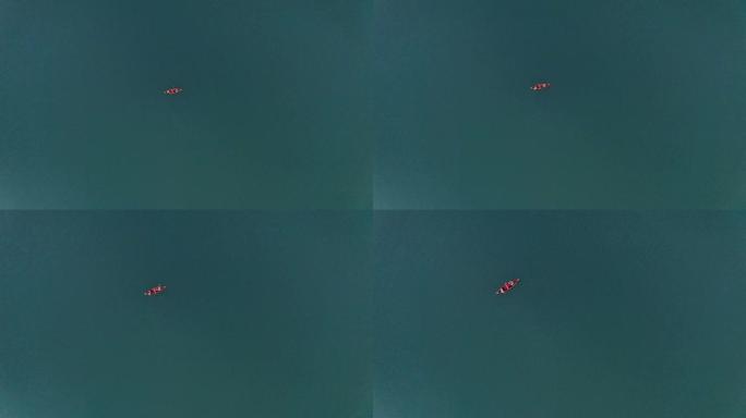 一个年轻的男孩和一个女孩正在湖上的划艇上航行