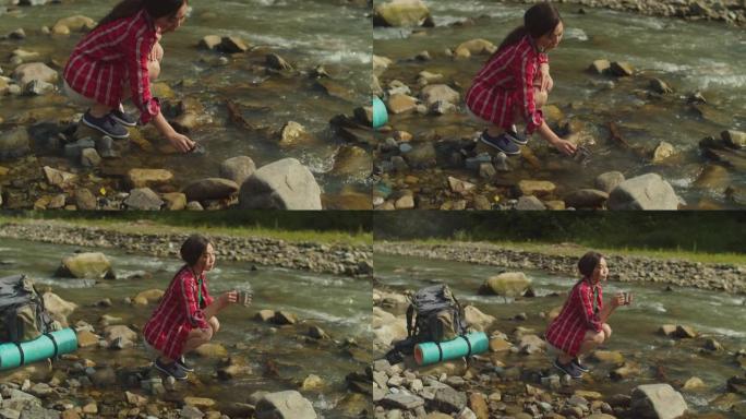可爱开朗的亚洲女性徒步旅行者用山河的冷淡水填充旅行杯