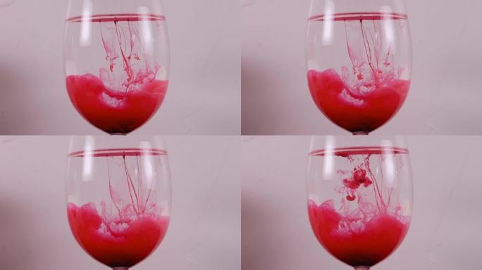 红色墨水在白色背景下的酒杯中旋转。