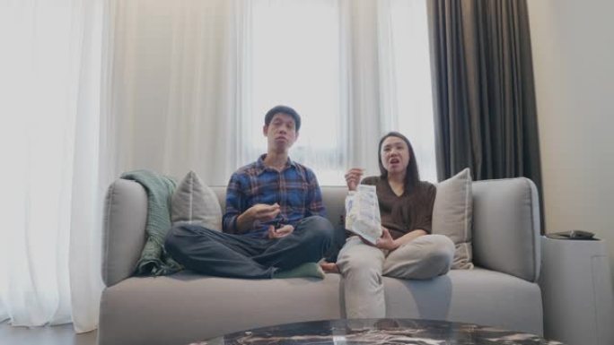年轻夫妇在家中通过计算机屏幕观看媒体