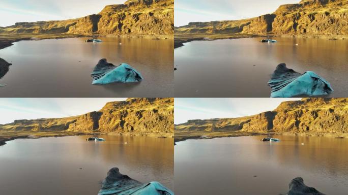 无人驾驶飞机在泻湖上，蓝冰朝向阳光普照的岩石景观