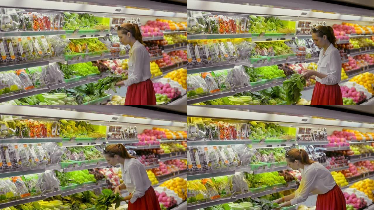 超市杂货店里的新鲜蔬菜。女人在冰箱里选择生菜