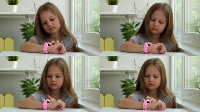 严肃的高加索小女孩点击儿童智能手表的屏幕。使用智能手表发送信息。技术、通信、儿童数字设备的概念