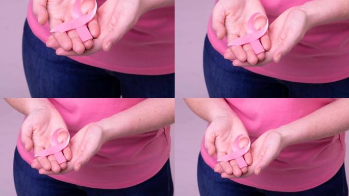白人妇女手持粉红癌症意识彩带的上腹部视频