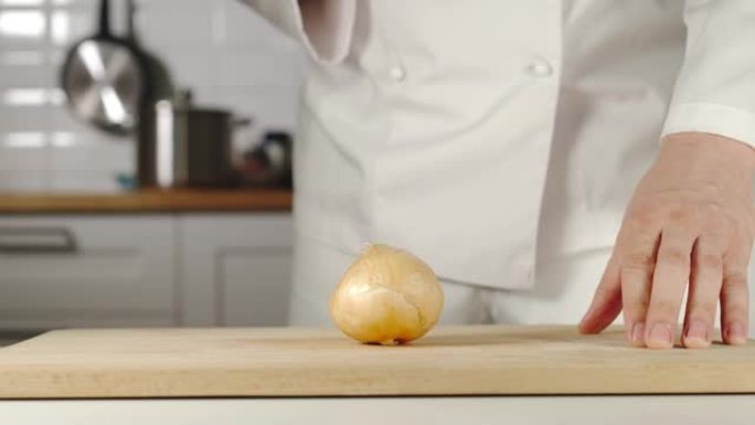 慢动作: 厨师在烹饪时在木板上切碎洋葱头