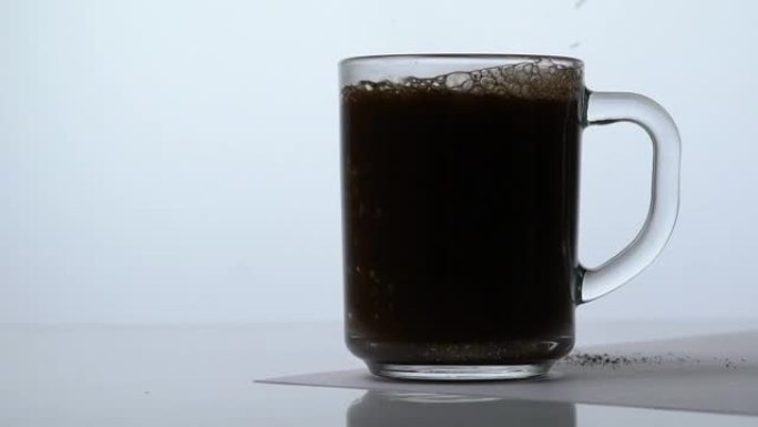 将咖啡倒入透明杯子中，并用开水倒入