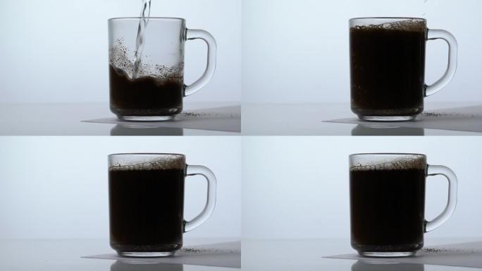 将咖啡倒入透明杯子中，并用开水倒入