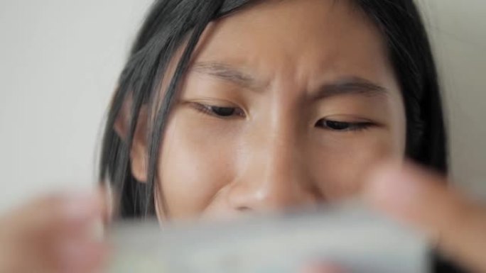 封闭亚洲女孩在家坐在床上玩手机游戏，生活方式理念。