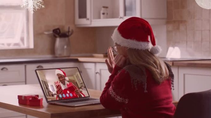 在与家人的笔记本电脑视频通话中，圣诞老人帽子上的女人在圣诞节雪花上的动画