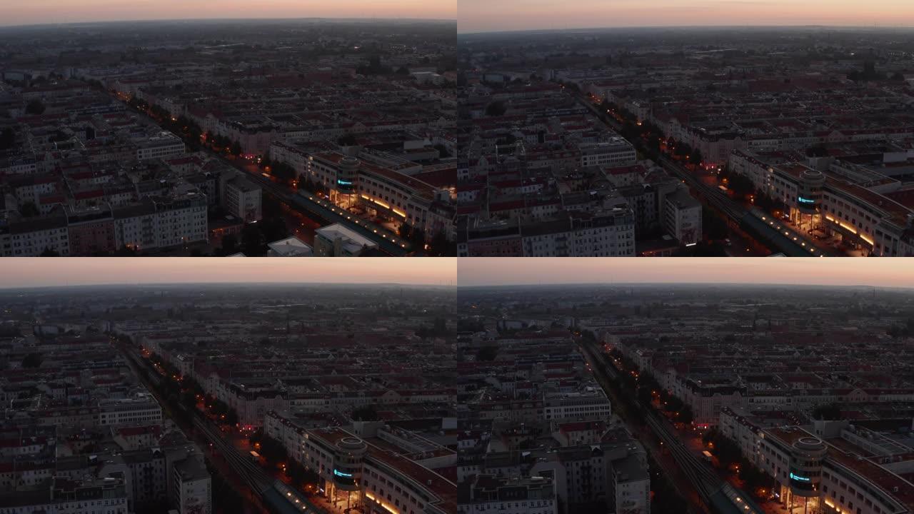 平移和倾斜早晨城市的镜头。日出前，宽阔的街道两旁是多层唐楼，橙色的暮色天空。德国柏林