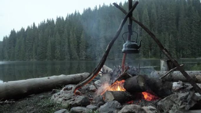 湖边野营壁炉上的老式茶壶。