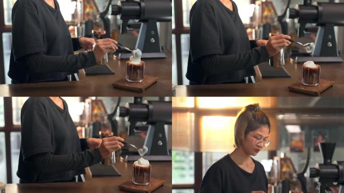 4k亚洲女咖啡师用泡沫牛奶制作冰巧克力，为顾客服务