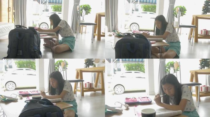 亚洲女孩在家学习在线课程时做作业，社交疏远生活方式理念。