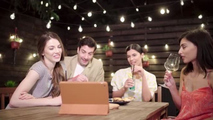 在视频通话中，一群宁静的人在晚上外出时享受鸡尾酒和随意的交谈