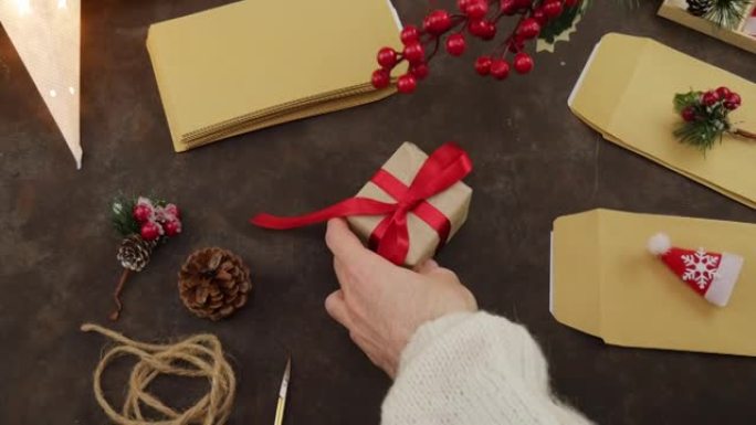 圣诞礼物。自制。带红色蝴蝶结的礼物
在手掌里。创造礼物。