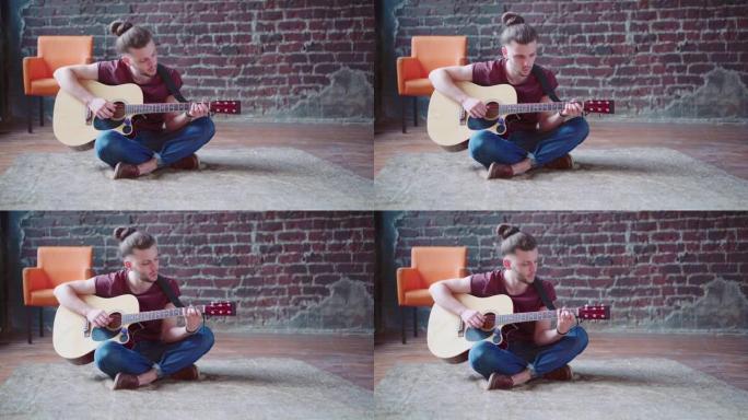 英俊的年轻人玩原声吉他坐地板客厅
