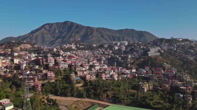 印度喜马偕尔邦索兰区绿谷的鸟瞰图。位于丘陵地区的发达城市的无人机视图。