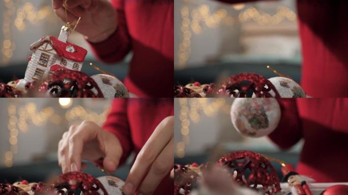 装饰圣诞树。女性双手从装有玩具的盒子里拿出圣诞玩具。特写和慢动作