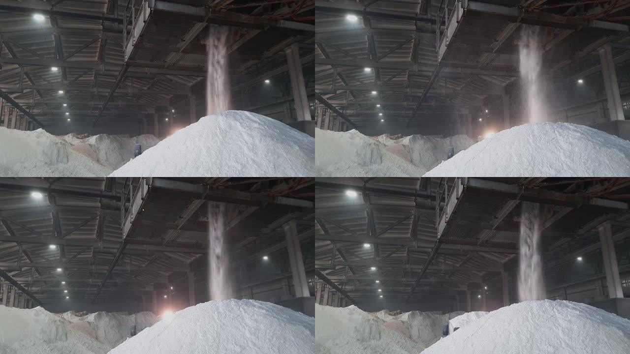 硫酸铵粉末倒入化工厂仓库内的一堆。农业用矿物有机肥料。