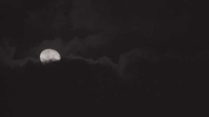 大部分是满满的发光的黄月，晚上有云被风吹动。
