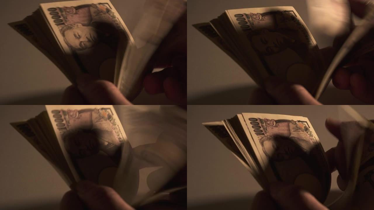 享受手中现金的男人。男人数日元钞票。
