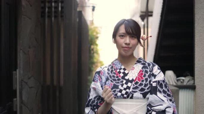 浴衣中的日本妇女走在狭窄的人行道上