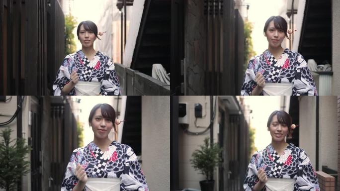 浴衣中的日本妇女走在狭窄的人行道上