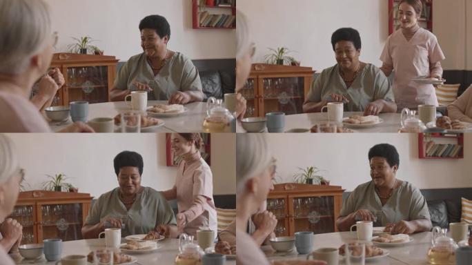 护士为养老院的老黑人女士带来早餐
