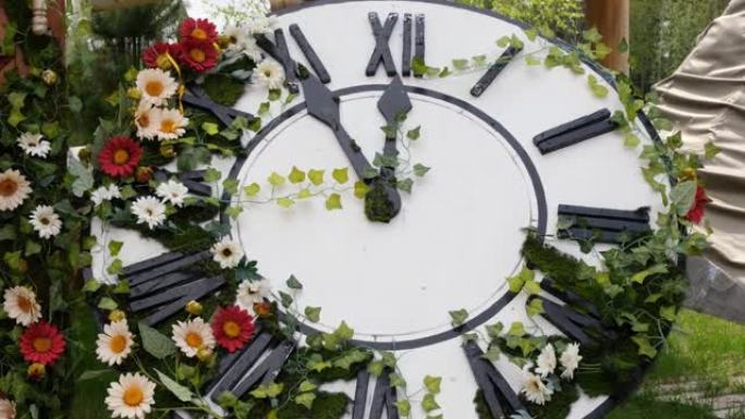 田野上盛开的大挂钟，显示时间11:55，12:00。时间管理理念，夏令时。春天或婚礼。妇女节野餐
