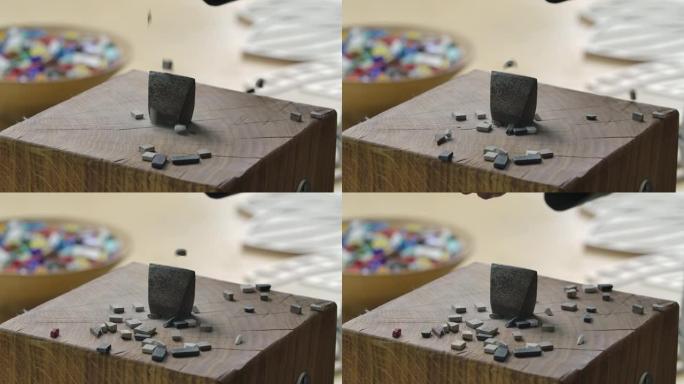 手锤的特写镜头来分离马赛克瓷砖。一种金属工具，上面倒入小块马赛克石头。在创意车间手工制作。慢动作