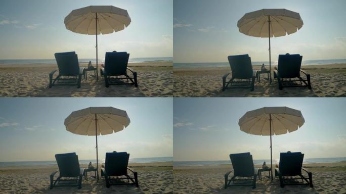 在泰国华欣的白色沙滩上，孩子们一起坐在沙滩椅上，遮阳伞。度假概念。