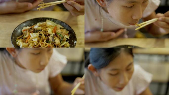 快乐的亚洲女孩和家人一起在日本餐厅享受她的食物，生活方式理念。
