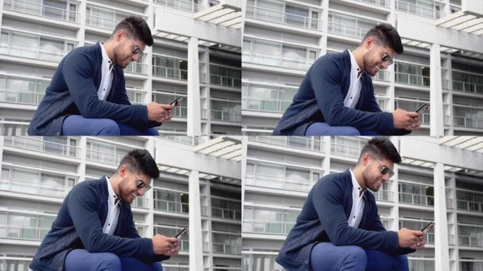 年轻英俊的男人在城市使用智能手机。微笑的年轻人用手机发短信。咖啡休息。现代生活方式、联系方式、商业理