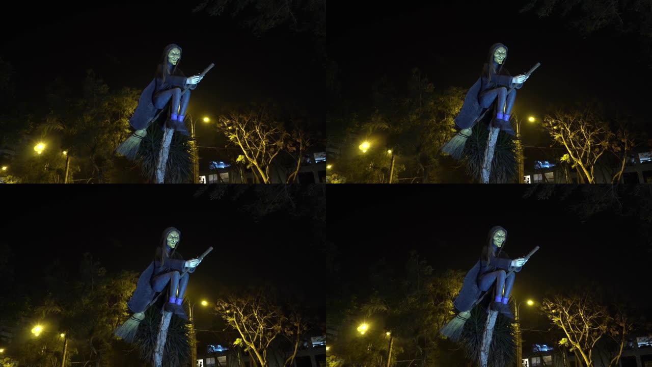 夜间公园稻草扫帚上可怕女巫的雕塑