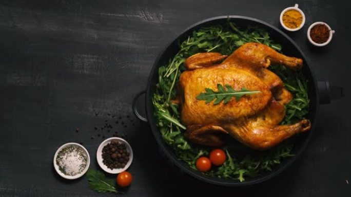 烤全鸡或火鸡放在铁锅里，放在黑色背景俯视图上。