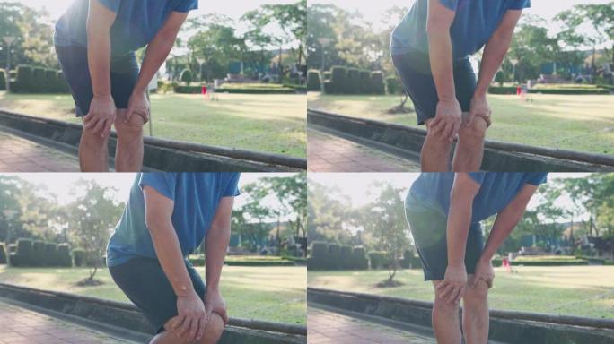 近距离拍摄亚洲男子在公园做膝盖热身，关节韧带骨问题，踝关节扭伤运动损伤预防，健康积极的生活方式，跑步