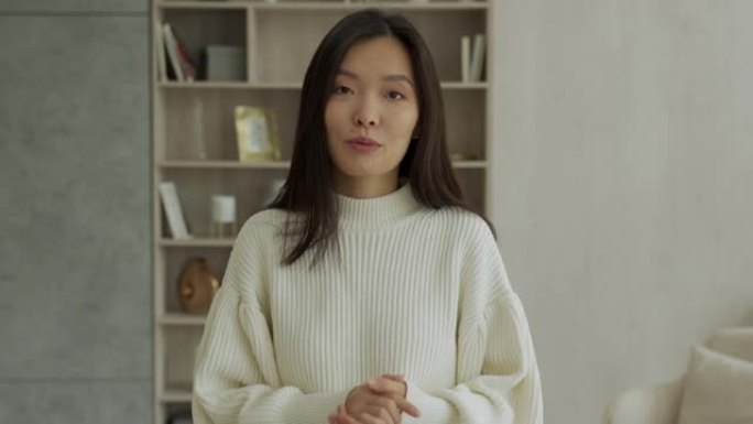 积极开朗的韩国女人看着镜头，借助在线技术在视频中交谈
