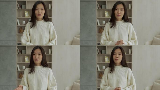 积极开朗的韩国女人看着镜头，借助在线技术在视频中交谈