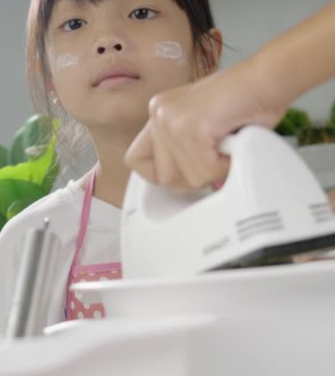 亚洲儿童在家与姐姐一起混合面团制作自制饼干，生活方式理念。