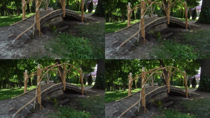 美丽的木制半圆形行人天桥在公园的小溪上，小溪在木圆木桥下流动
