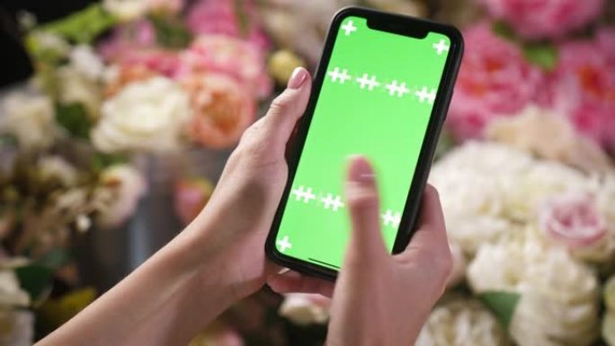 女孩手握iphone智能手机，带绿色模型色度键屏幕，用于广告