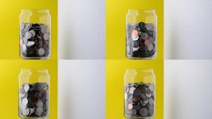 玻璃瓶中的硬币慢慢地绕着它转。玻璃瓶里的钱视频。省钱。未来的储蓄想法。