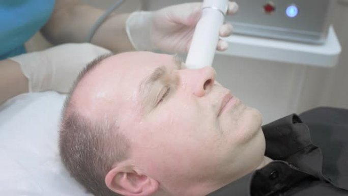 面部男性皮肤的美容程序。非手术除皱。治疗师对男性客户进行血浆提升。