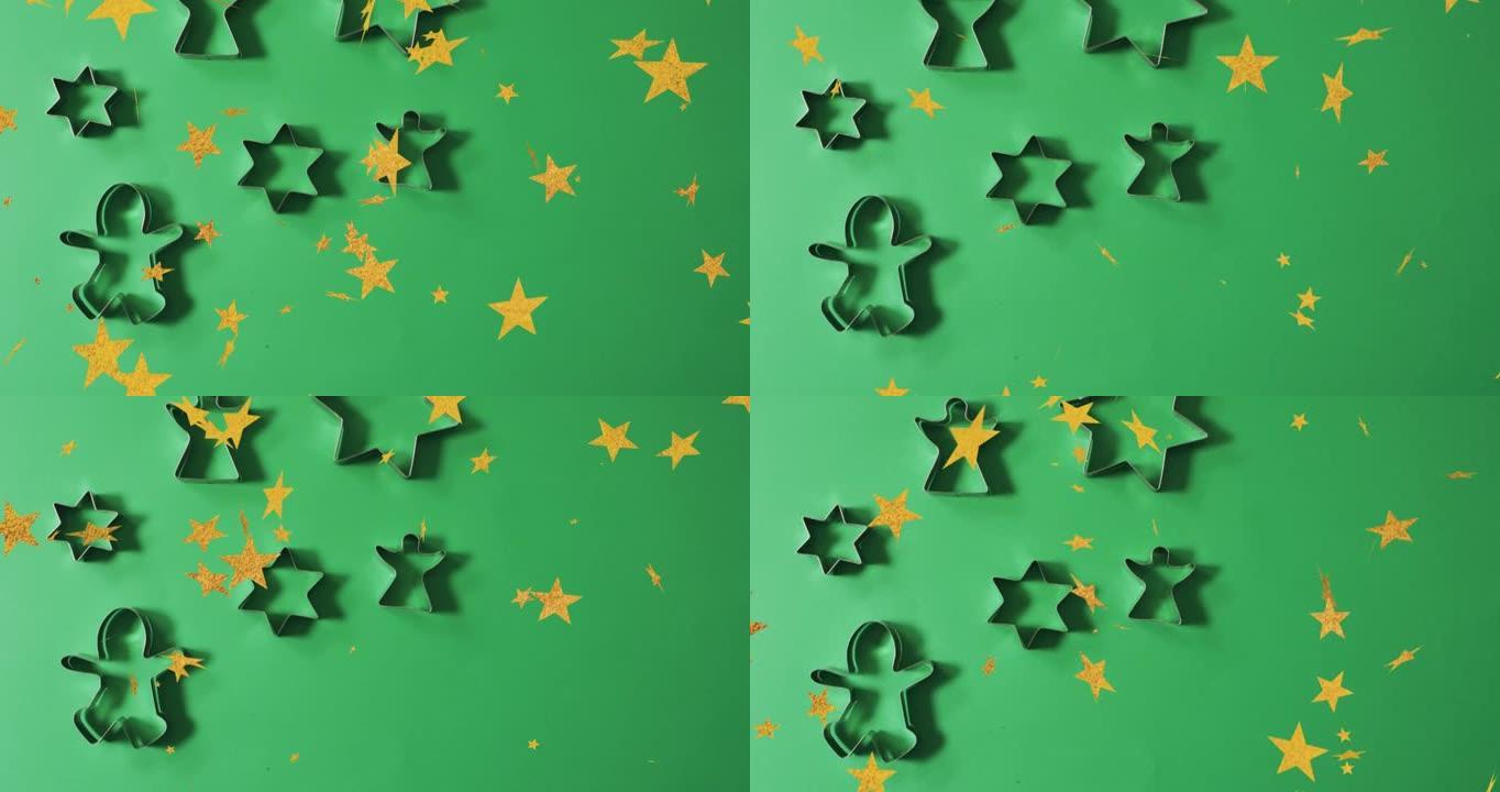 圣诞明星的动画落在绿色背景上的饼干模具上
