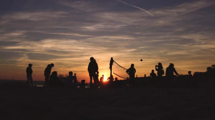 人们在日落时打排球的剪影