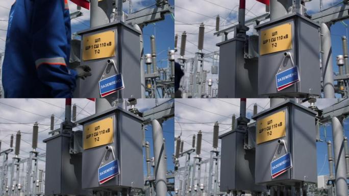 技术人员在车站的电容器组上悬挂接地的标志