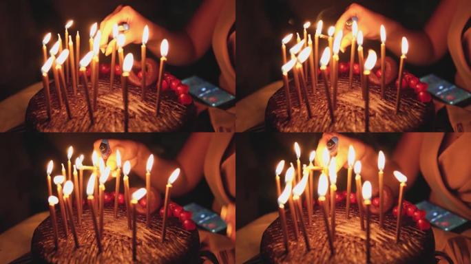 女人在巧克力蛋糕上点燃生日蜡烛