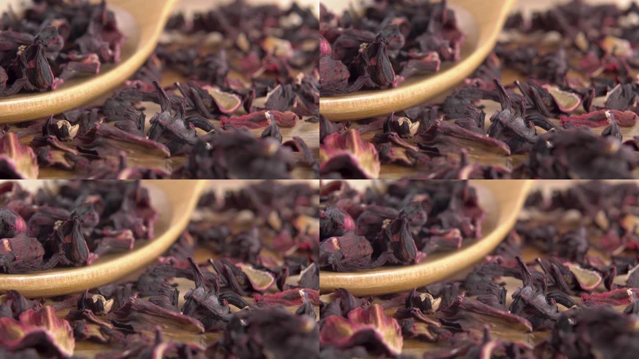 在木质表面的木制乡村勺子中干燥红色芙蓉茶