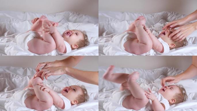 女人的手挠痒痒可爱的7个月女婴躺在床上
