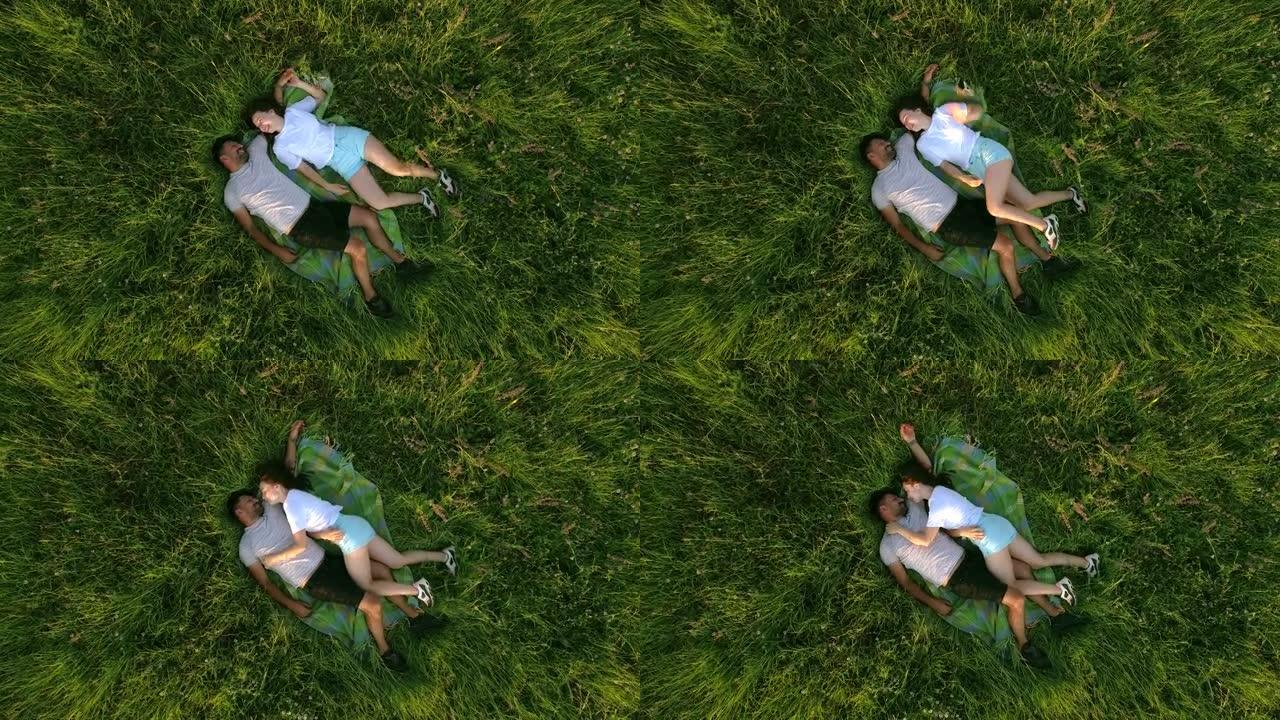 幸福的夫妇躺在绿草地上